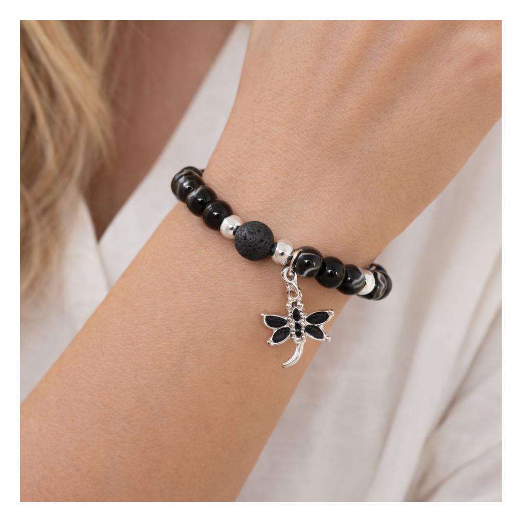 Black Botswana agate and lava stone dragonfly charm bracelet shown on a wrist — boho handmade jewelry
