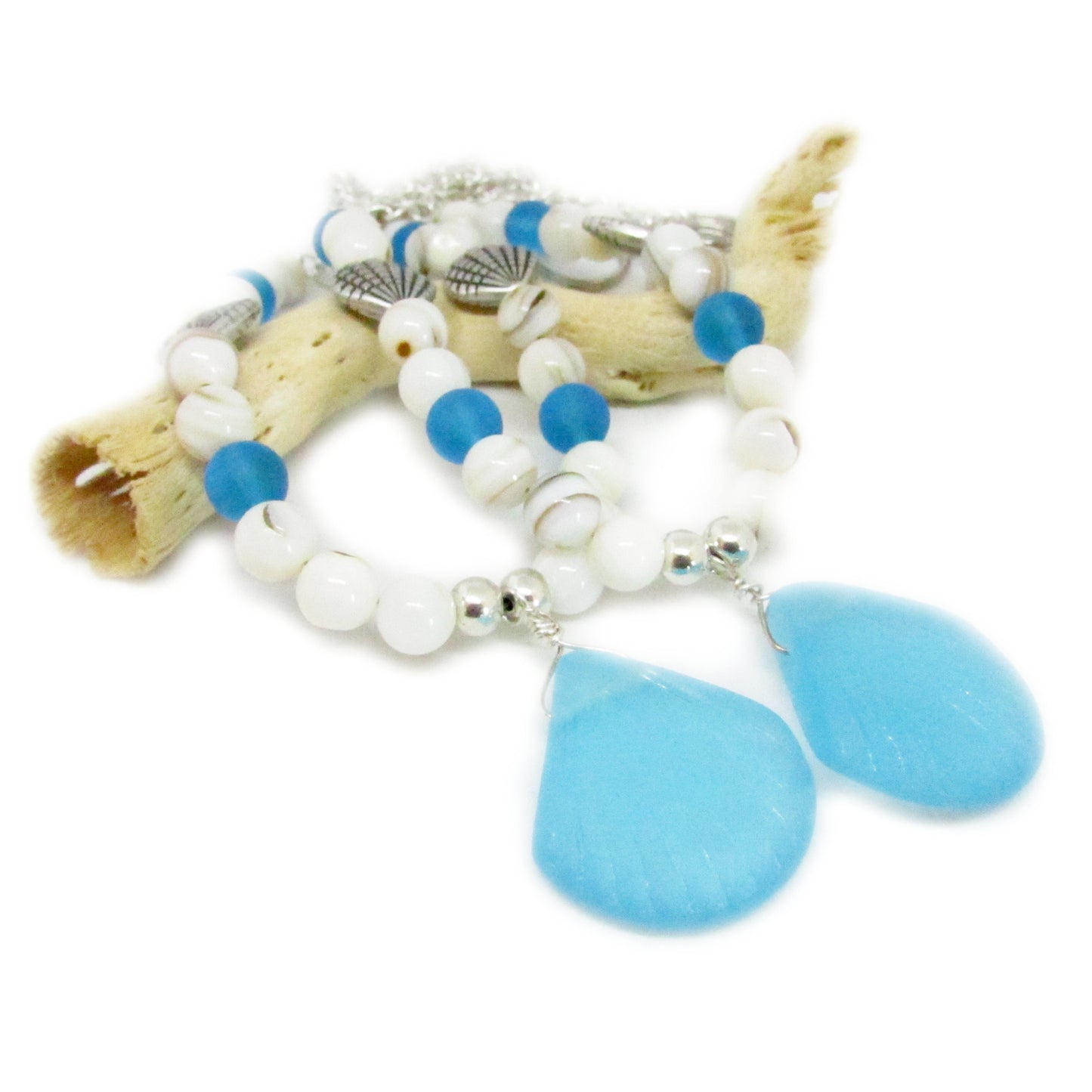Coastal curtain tieback set laid flat showing blue sea glass, white shell beads, and silver shell accents