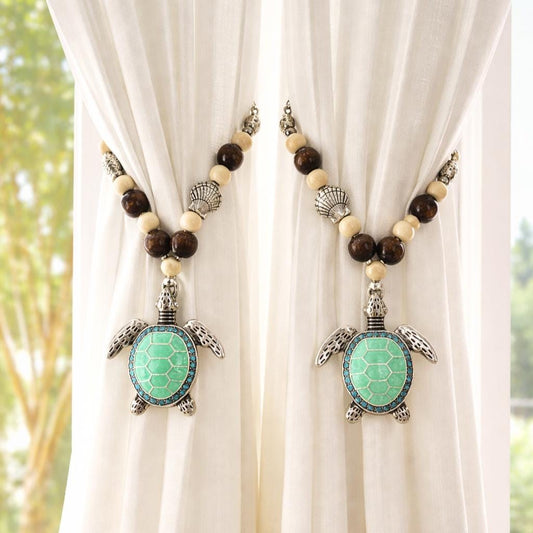 Set of two sea turtle beaded curtain tiebacks shown styled on sheer curtains — handmade coastal beach home decor