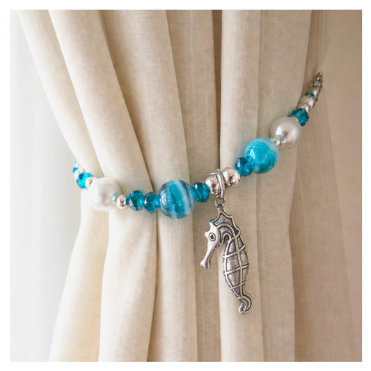 Seahorse and teal bead curtain tiebacks shown styled on sheer curtains — handmade beach cottage home decor
