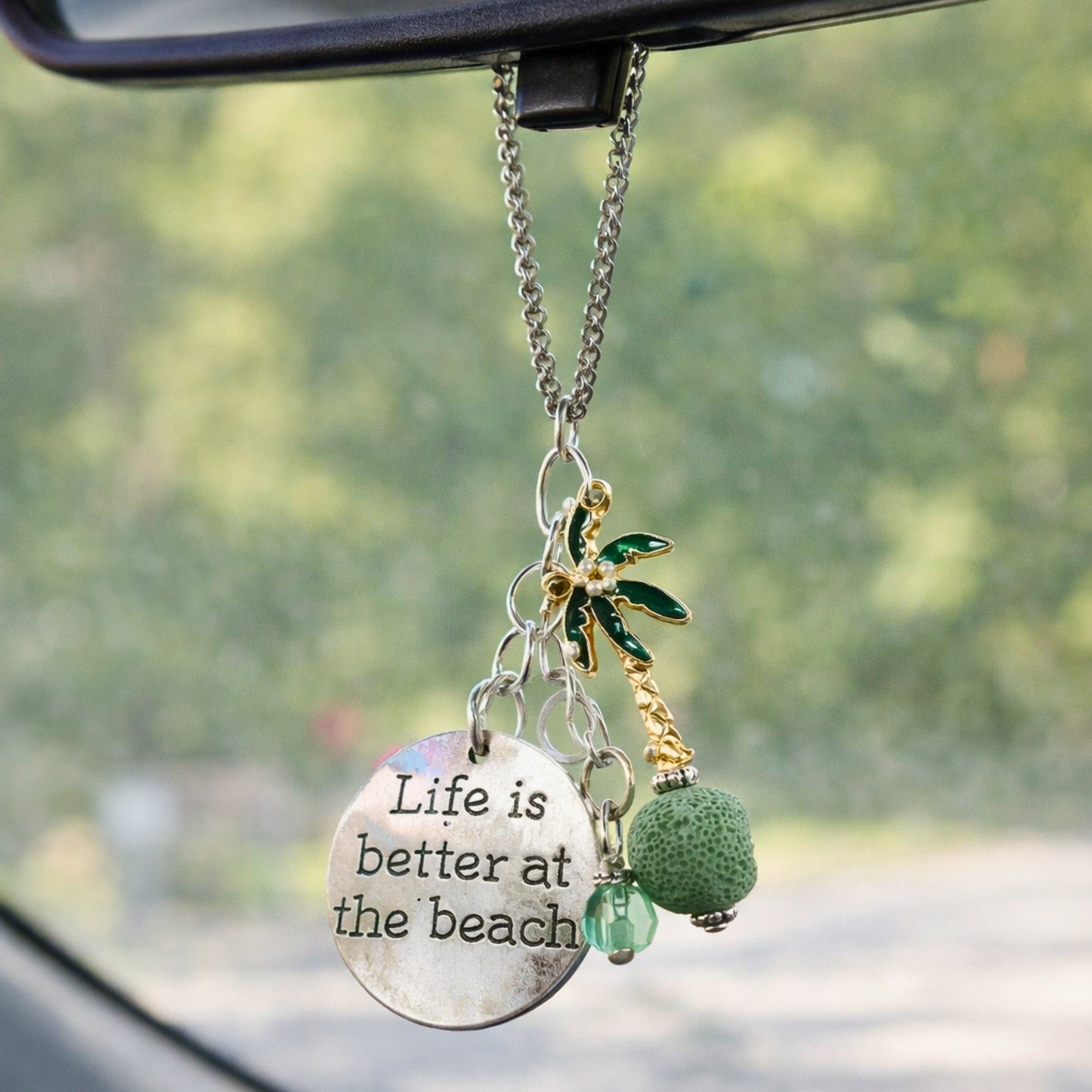 Palm tree essential oil car diffuser charm shown hanging from a rearview mirror — handmade coastal car accessory