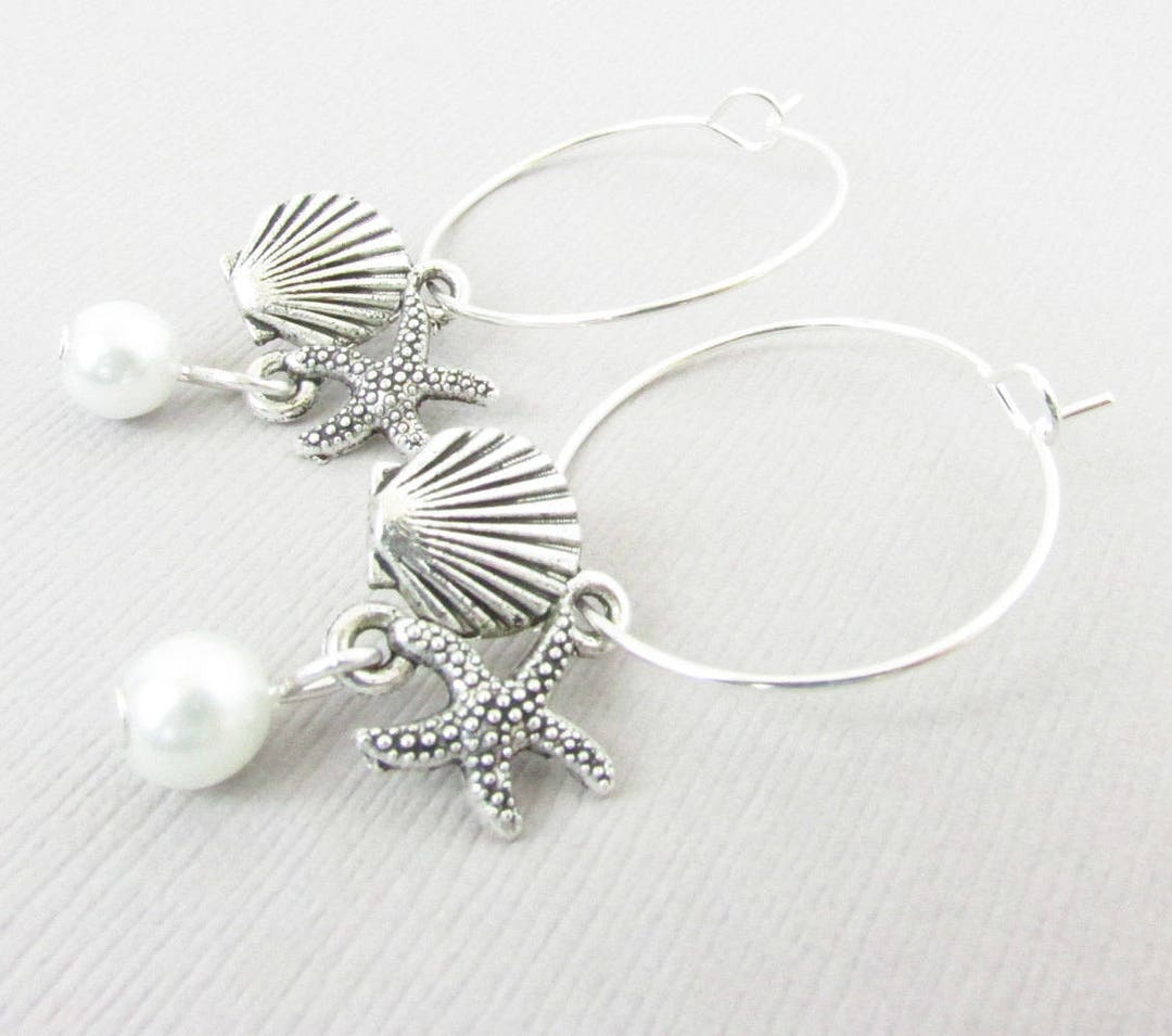 Silver hoop earrings with pearl seashell and starfish charm close up