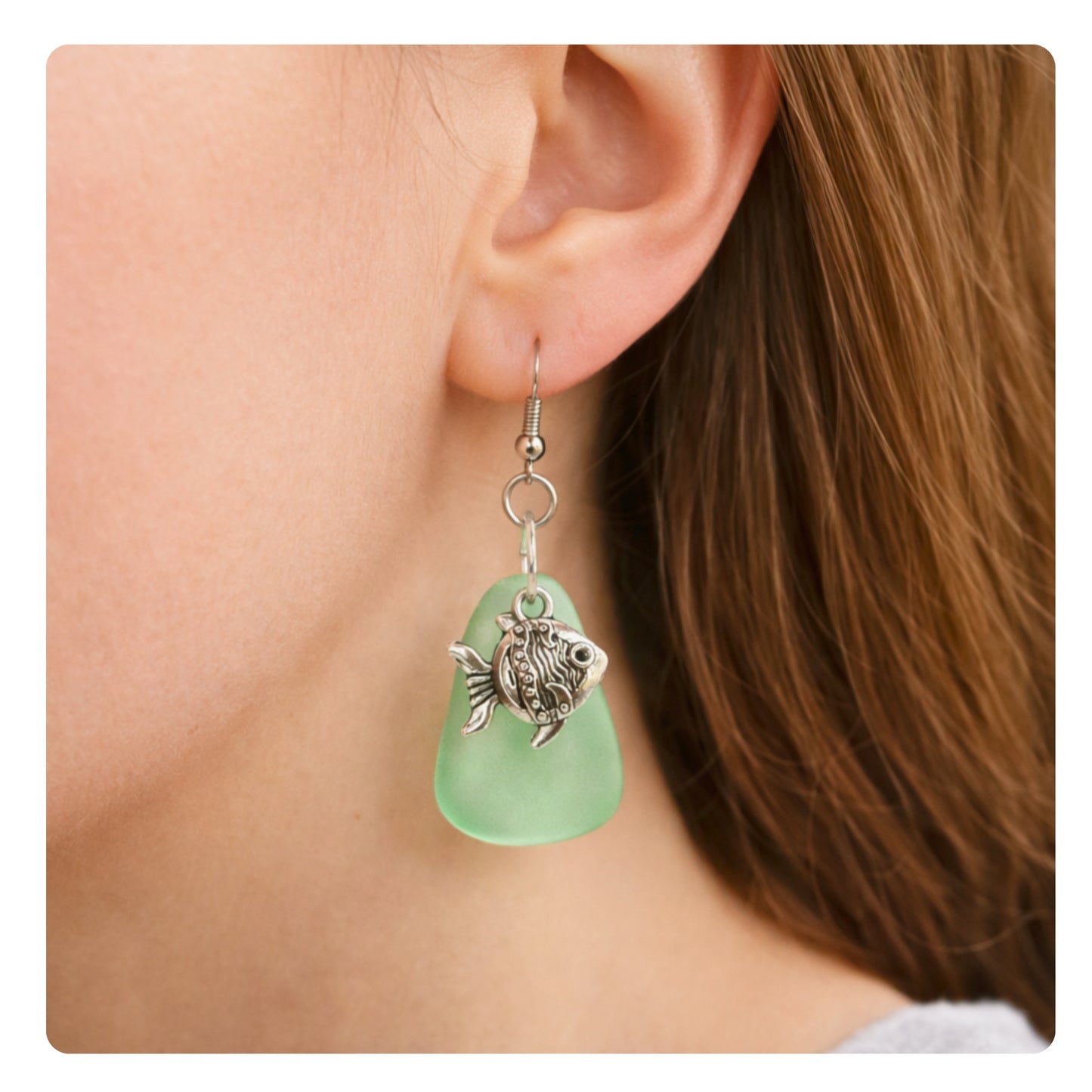 Green sea glass goldfish dangle earrings shown on a model — handmade beach jewelry
