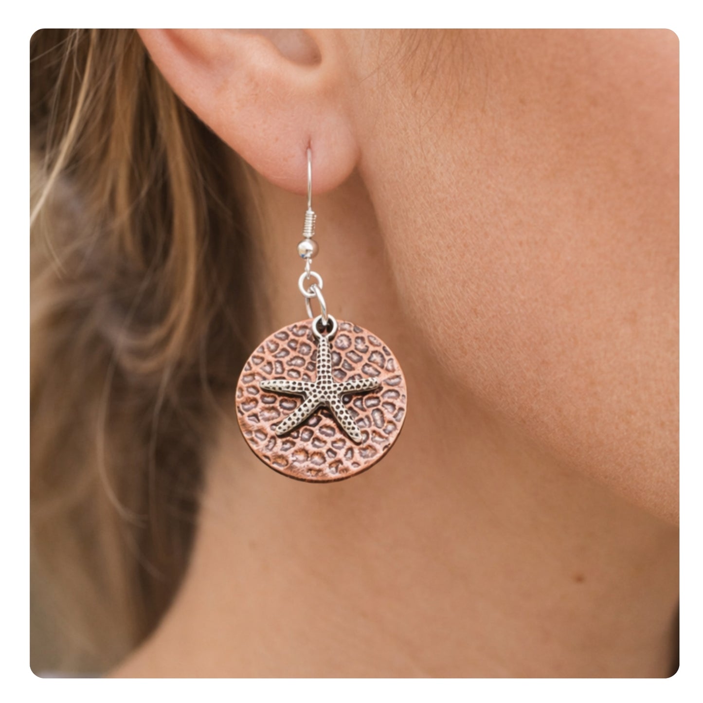 Hammered copper starfish dangle earrings shown on a model — handmade beach jewelry
